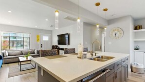 A modern kitchen with a central island, stainless steel appliances, pendant lighting, and a large window. - Walk 2 Old Town, Sparkling Pool, Fire Pit, Oasis (Scottsdale)