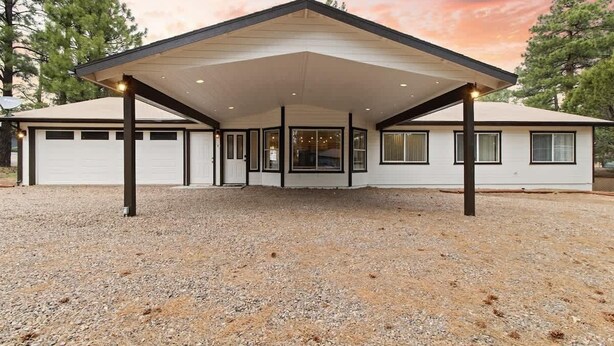 A single-story house with a covered patio area, a garage, and a gravel driveway. - Spacious 4-BR Home, Near Fool Hollow Lake (Show Low)