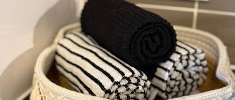 Un panier contenant des serviettes enroulées à rayures noires et blanches.