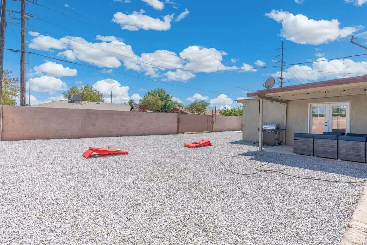 A building with a gravel driveway, a small structure with a door and windows, and a satellite dish on the roof.