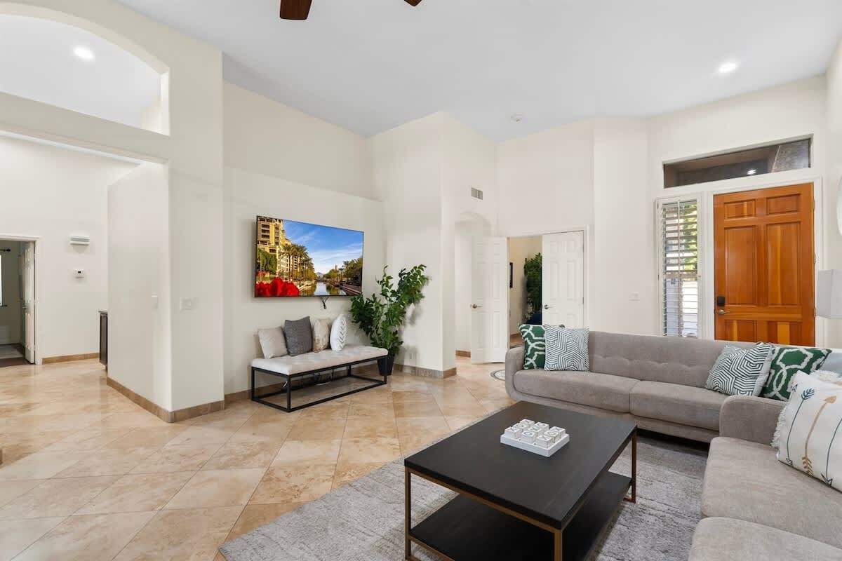 A spacious living room with a sofa, coffee table, and a painting on the wall.