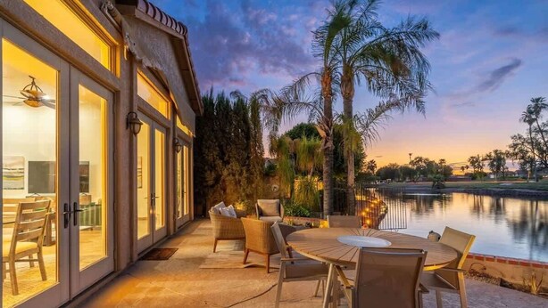 A patio with a table and chairs, a pool, and palm trees. - Lakeside home with private patio, Grill, Golf view (Glendale)