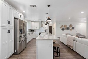 A modern kitchen with white cabinetry, stainless steel appliances, and a central island. - 5BR, Heated Pool, BBQ and Covered Patio - DT Phx (Phoenix)