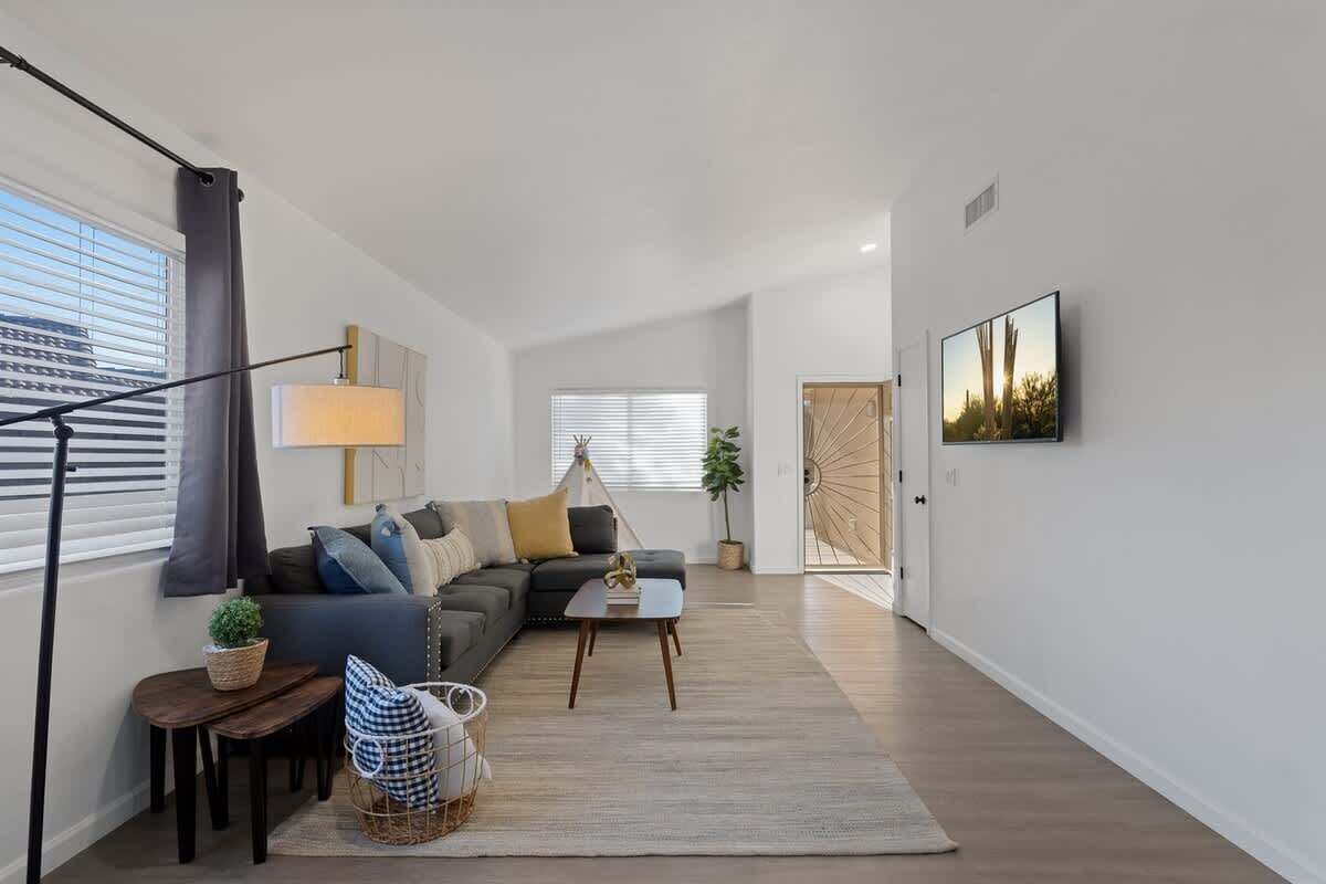 A modern living room with a sofa, coffee table, lamp, and a framed picture on the wall.