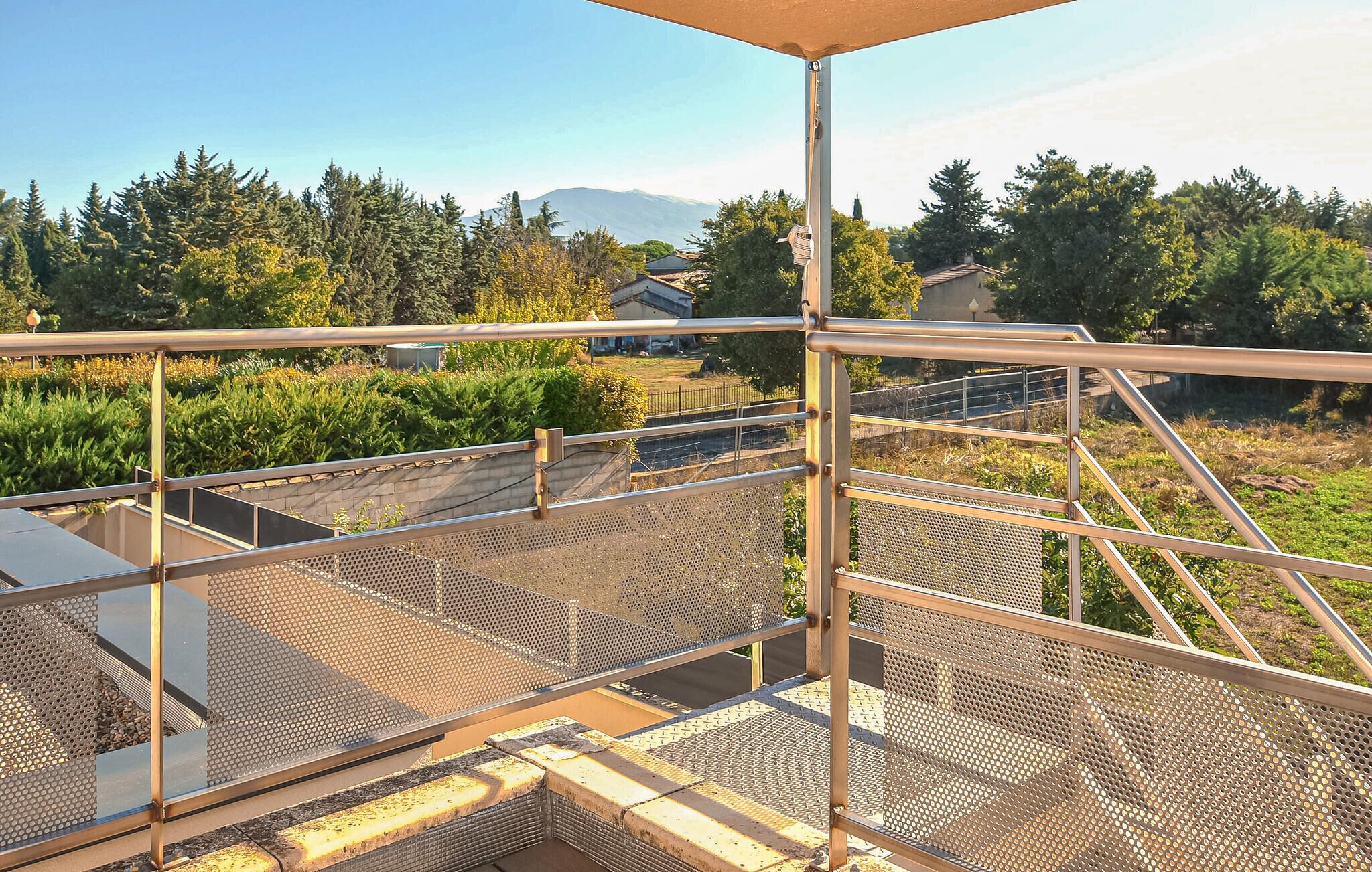 A metal staircase with a mesh railing leading to a covered area.