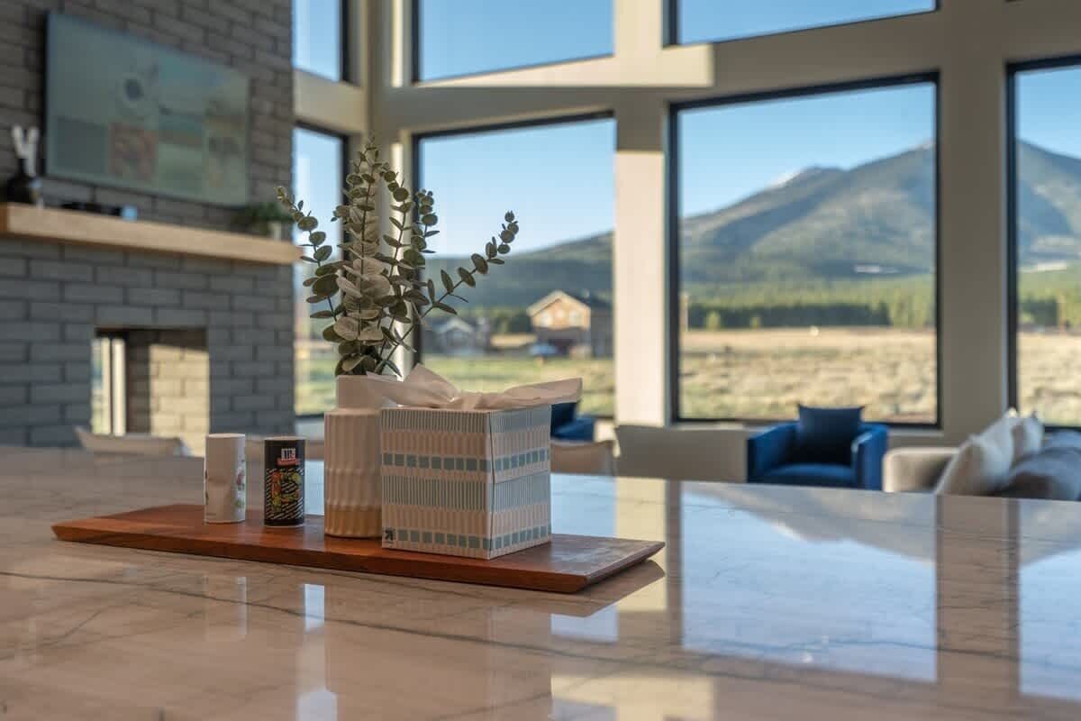 A modern living room with a large window overlooking a mountainous landscape.