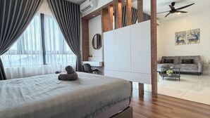 Une chambre moderne comprenant un lit, une armoire, un ventilateur de plafond et un coin salon avec un canapé et une table basse.