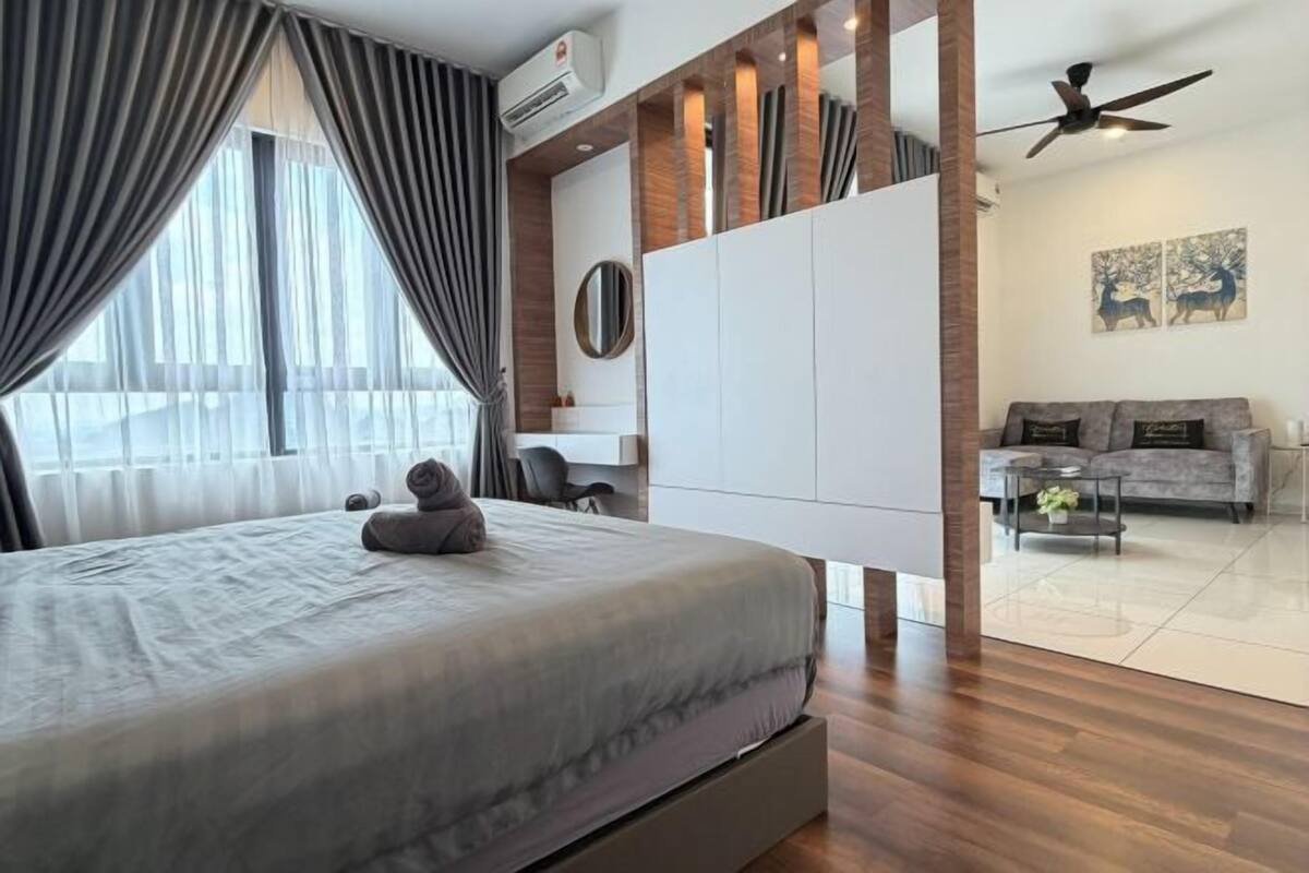 Une chambre moderne comprenant un lit, une armoire, un ventilateur de plafond et un coin salon avec un canapé et une table basse.