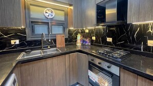 Une cuisine moderne équipée d’un four encastré, d’un évier et d’une cuisinière.