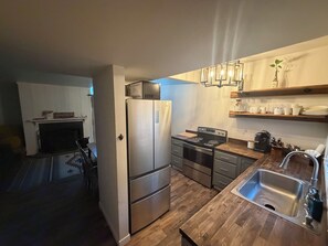 Een moderne keuken met roestvrijstalen apparatuur, houten werkbladen en een inbouwoven.
