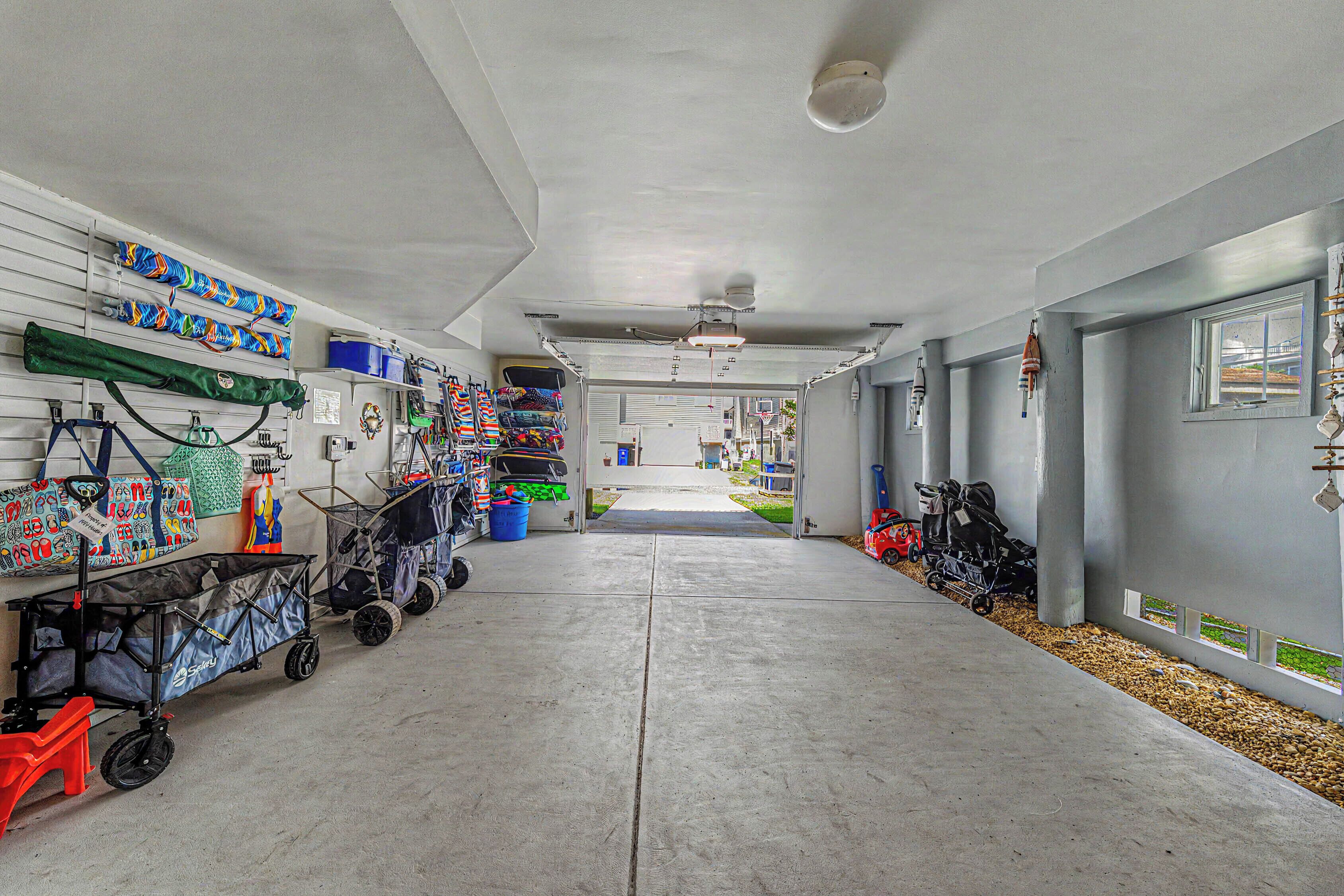 A garage with a concrete floor, various baby strollers, and storage shelves.