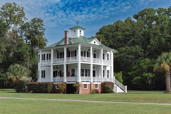 A two-story house with a green roof, white exterior, and a porch with white railings. - Historic Beaufort Estate - Near Downtown Beaufort & Parris Island (Beaufort)
