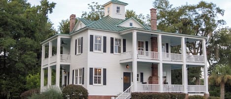 Ein zweistöckiges Haus mit Veranda und Schornstein.