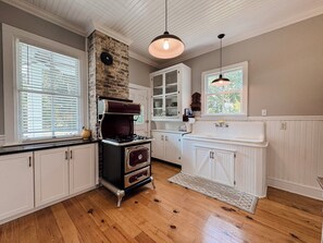 A kitchen with a vintage stove, white cabinetry, and a wooden ceiling. - Historic Beaufort Estate - Near Downtown Beaufort & Parris Island (Beaufort)