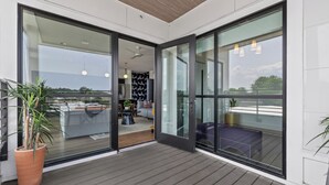 A modern interior with a sliding glass door leading to a balcony. - 2 Condos-8 Minutes to Broadway-Walkable-5 King (Nashville)