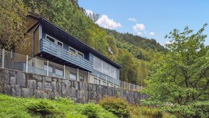 Ein modernes, zweistöckiges Gebäude mit einer Steinmauer und einem Metallzaun.