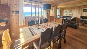 A cozy cabin interior with a wooden dining table, chairs, and a sofa. - Awesome home in Eggedal with sauna (Eggedal)