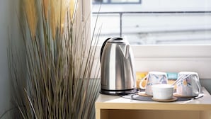 A room with a window, a potted plant, a kettle, and a breakfast tray. - Wanderlust NZ (Tauranga)