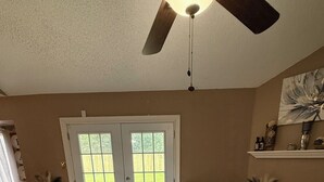 A living room with a sectional sofa, a fireplace, and a ceiling fan. - This cozy home is a beautiful 3 bedroom, 2 full bathroom as  with a 2-car garage (Baton Rouge)