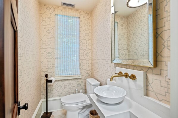 Une salle de bain avec des toilettes, un lavabo et une fenêtre.