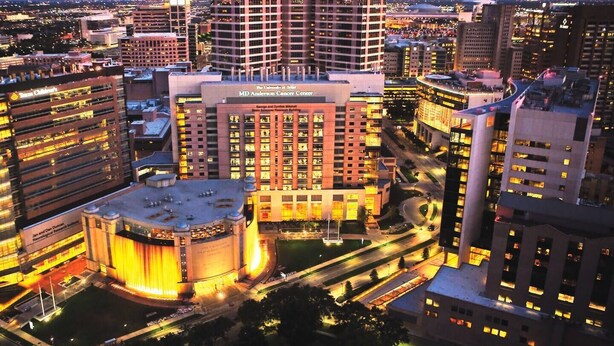 A multi-story building with a central atrium and a large circular structure at the base.