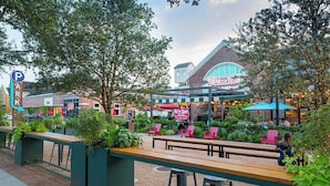 An outdoor seating area with a café, a parking sign, and a building with a sign that reads "D'Amico's Market Café".