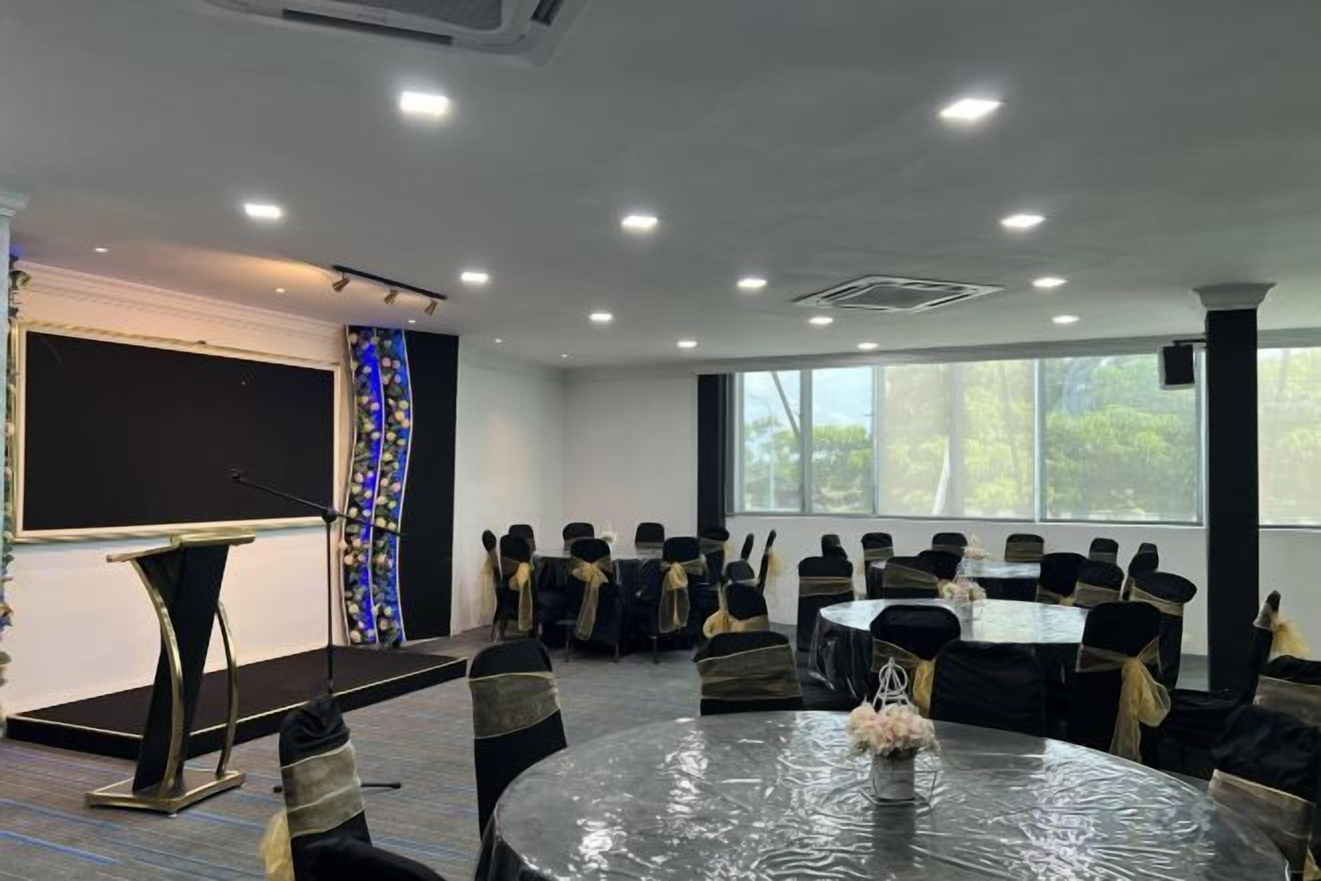 A conference room with a stage, chairs, and a round table.