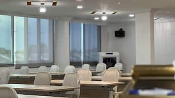 A classroom with rows of desks, chairs, and a projector screen.