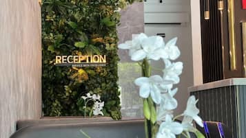 A reception area with a green wall and a sign that reads 'RECEPTION SERVICE WITH EXCELLENCE.'