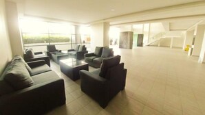 A spacious living area with a sofa set, a coffee table, and a view of the outdoors. - Ayuman Suites, Gombak with KL City View (Gombak)