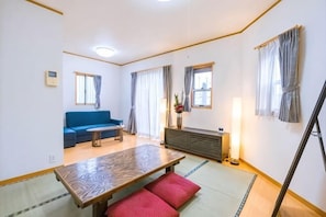 A room with a sofa, a dining table, a TV, and a cabinet. - Katsushika Takasago House (Tokyo)