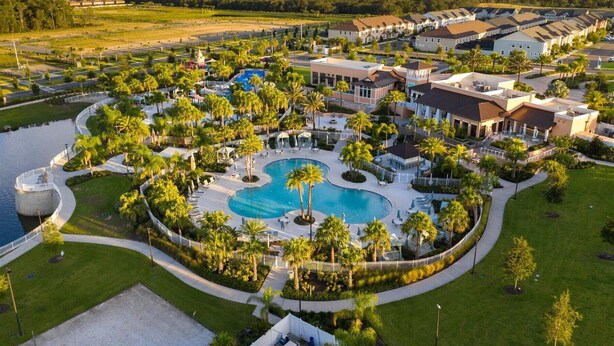 A resort with a large central pool, multiple buildings, and surrounding greenery.