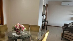 A dining area with a glass table, four chairs, and a vase of flowers. - 🌍 COP30 in Belém – Stay in Style and Comfort! 🏢 High floor | 220 m² (Belém)