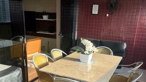 A dining area with a table and chairs, a fan, and a red tiled wall. - 🌍 COP30 in Belém – Stay in Style and Comfort! 🏢 High floor | 220 m² (Belém)