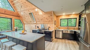 Una cocina moderna con paredes de madera, una isla grande y electrodomésticos de acero inoxidable.