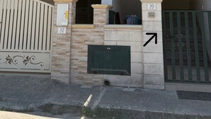 A modern two-story building with a flat roof, a covered entrance, and a gated driveway. - Sofia House, close to the center and the sea (Torre San Giovanni)