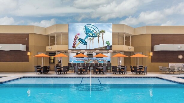 A hotel pool area with a bar and seating.