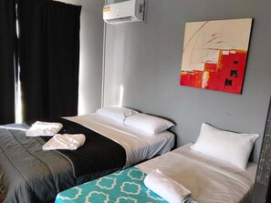A hotel room with two beds, a painting on the wall, and an air conditioning unit. - Maryborough Motel and Conference Center (Maryborough)