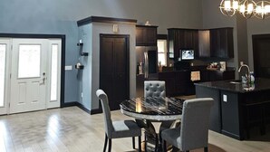 A modern kitchen with dark cabinetry, a central island, and pendant lighting.