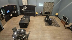 A spacious room with a dining area, a seating area, and a fireplace.