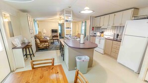 Een compacte keuken met een eethoek, een knusse zithoek en een kitchenette.
