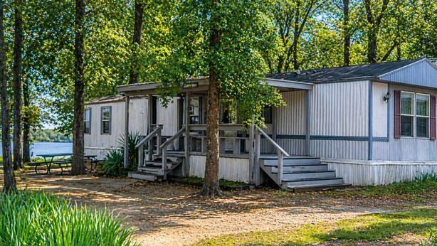 Een chalet met een veranda, een trap en uitzicht op het meer.