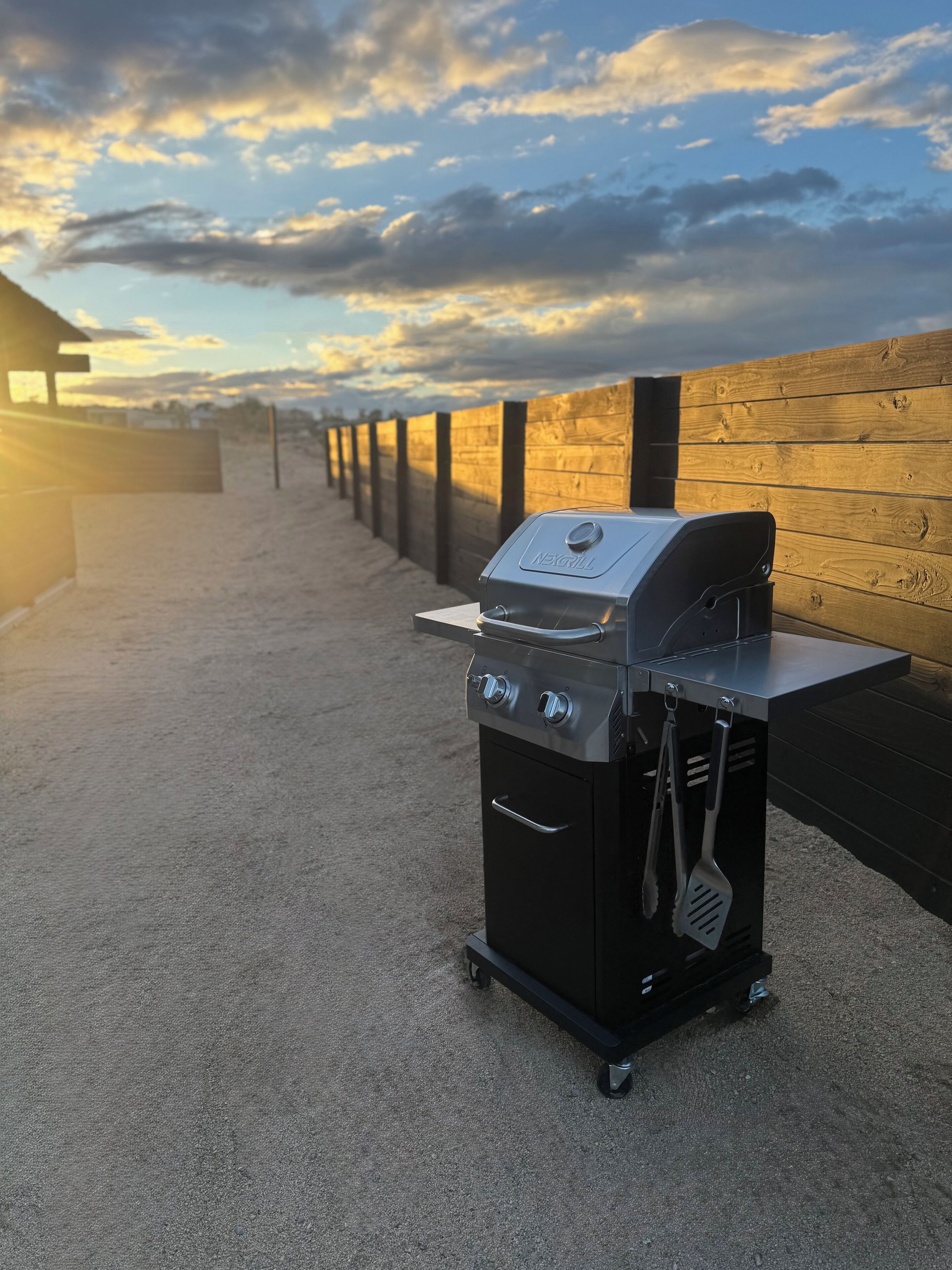 A portable grill with a digital display, a side handle, and a built-in thermometer.
