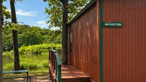 Ein hölzernes Gebäude mit der Aufschrift 'NAVIGATION', mit einer Holztreppe, die zu einem Deck mit Blick auf einen See führt.