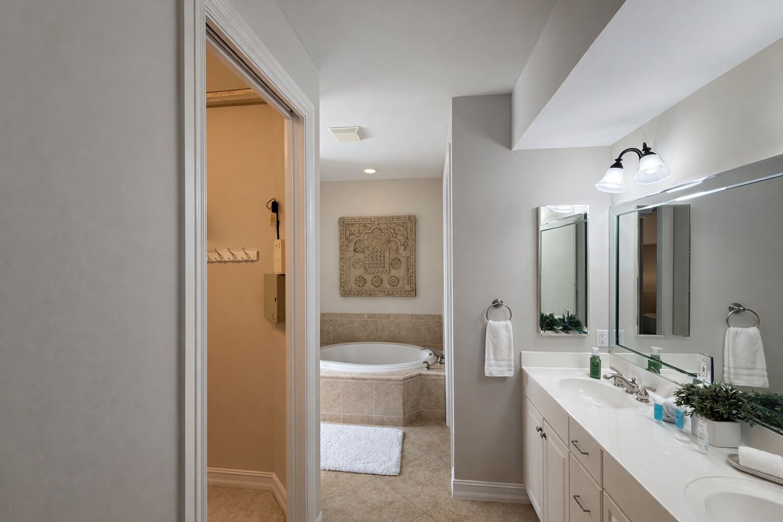 Un bagno moderno con una vasca, un grande specchio e un mobile lavabo.