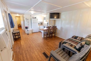 Un espacio habitable compacto con kitchenette, comedor y sofá.