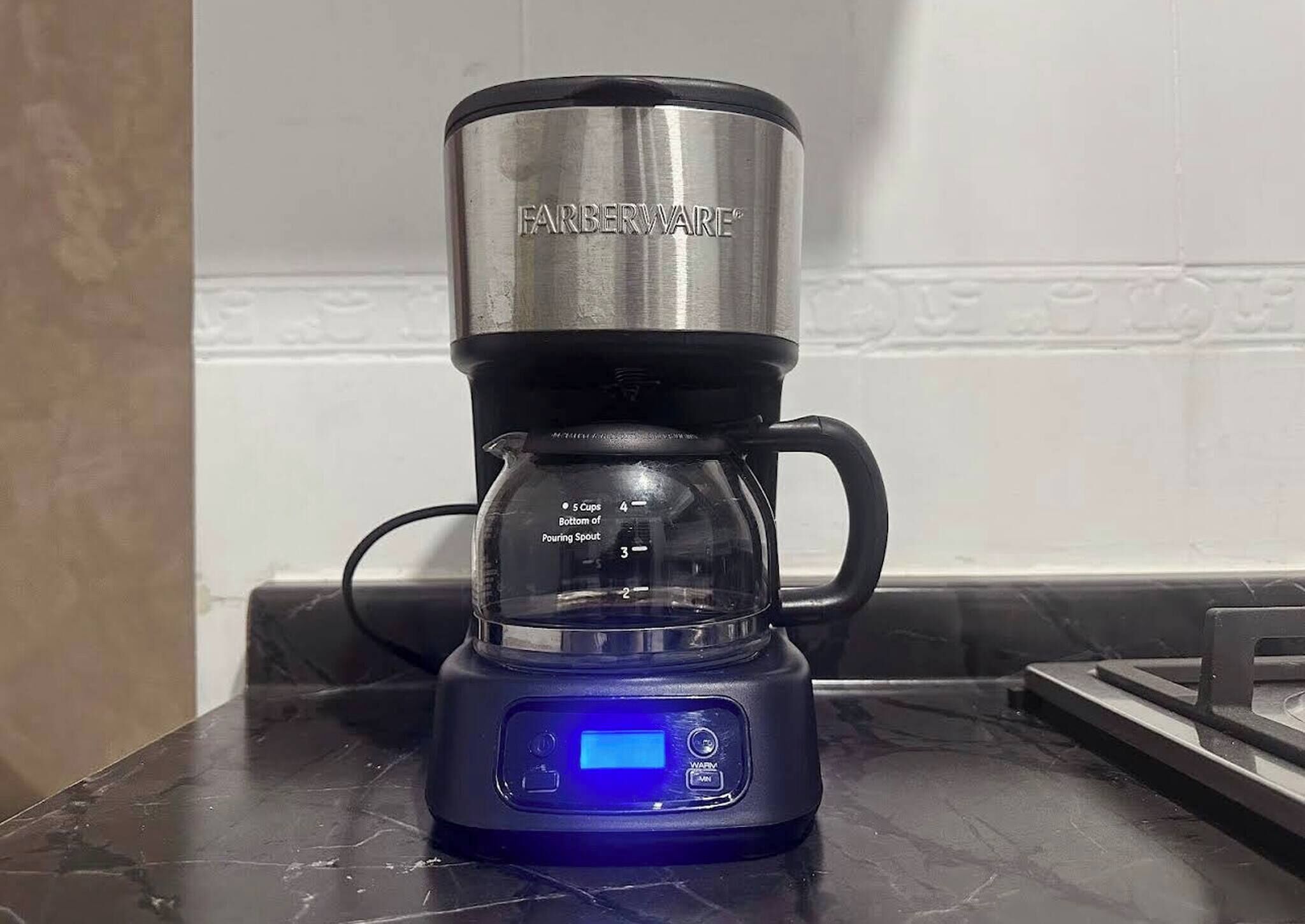 A Farberware coffee maker with a digital display on a kitchen counter.