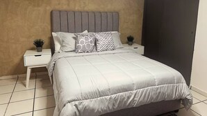A bedroom with a bed, two nightstands, and a door. - Casa Privada 3 Hab 6p Plaza de Toros Centro (Guadalajara)