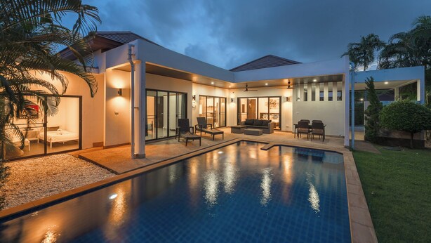 A modern poolside area with a swimming pool, outdoor seating, and a covered patio. - 4Br Near Pier Private Pool & Garden V246 (Rawai)