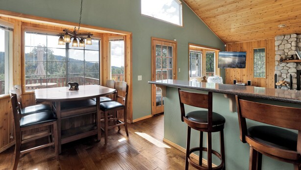 Una cocina amplia con una isla grande, techo de madera y ventanas grandes que ofrecen vistas al exterior.